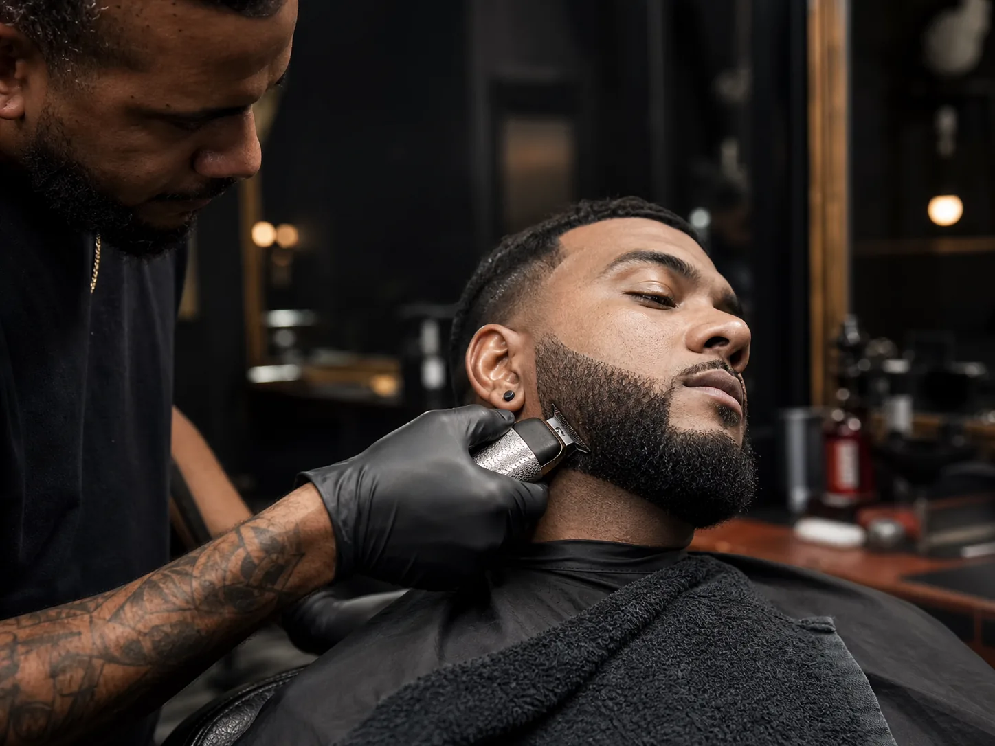 A Cutline barber shaping a client's beard line with clippers